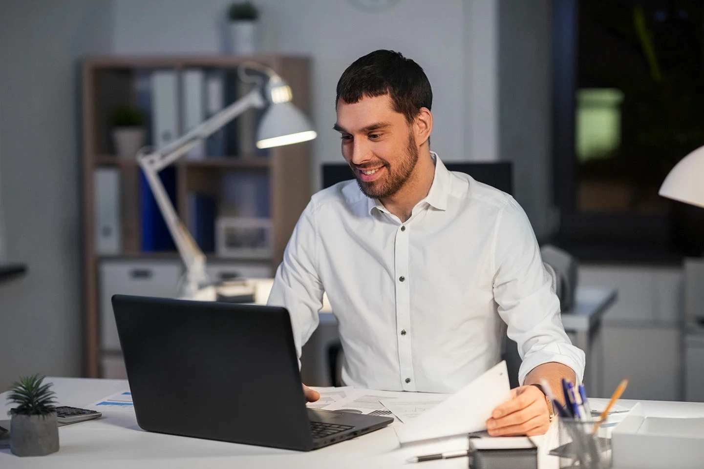 Un homme assis à son bureau devant son ordinateur